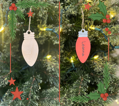 Two Christmas tree ornaments hanging on a decorated tree with lights and holly.