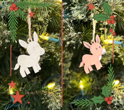 Festive nativity donkey ornament hanging on a decorated tree.