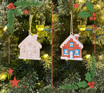 Two gingerbread house ornaments hanging on a Christmas tree with lights and decorations.