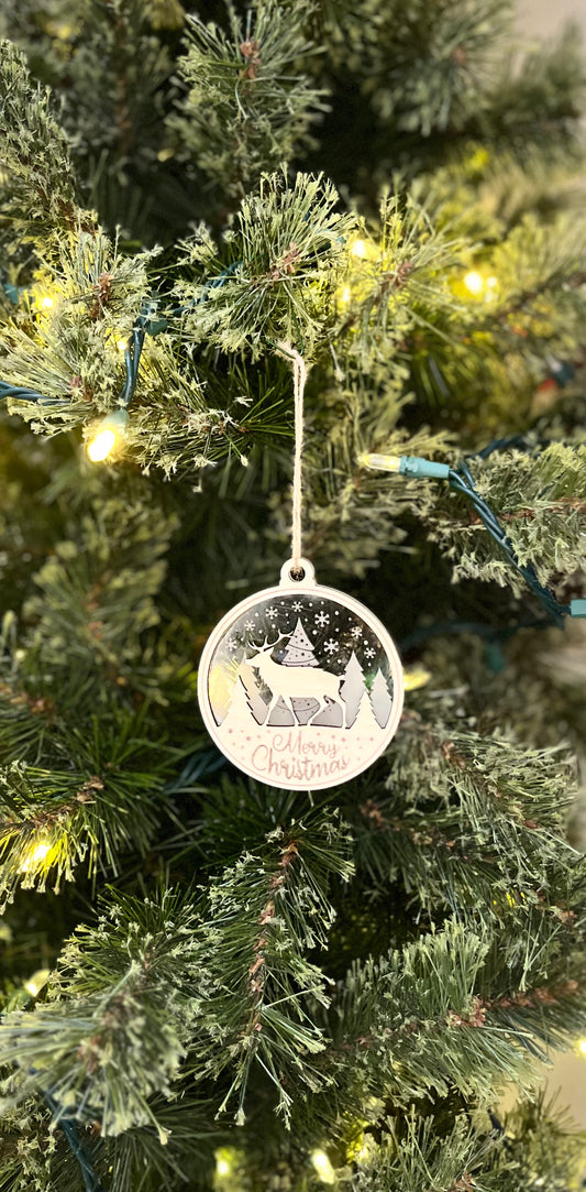 Decorative ornament on a Christmas tree with a reindeer design.