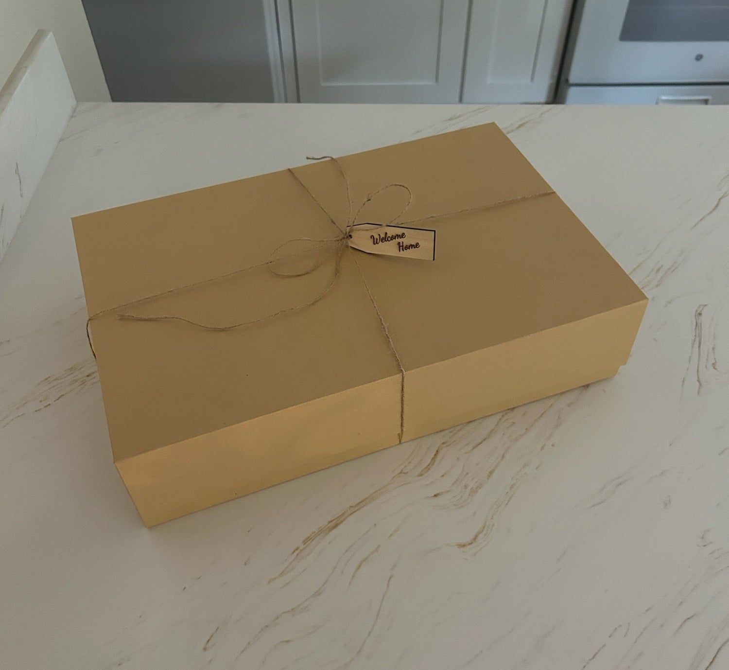 Brown gift box with a tag on a marble countertop in a kitchen