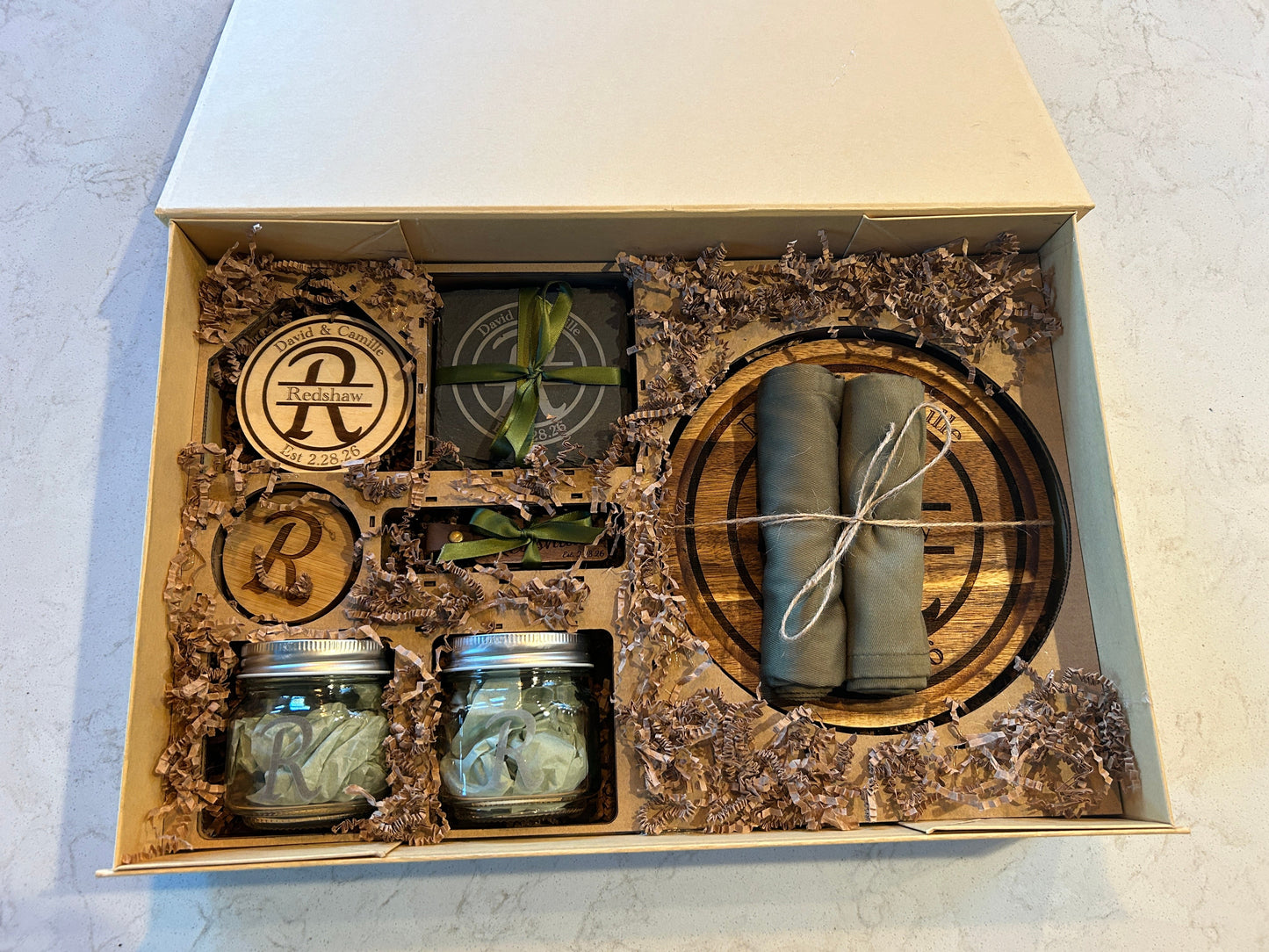 Gift set with jars, rolled items, and decorative elements in a box.