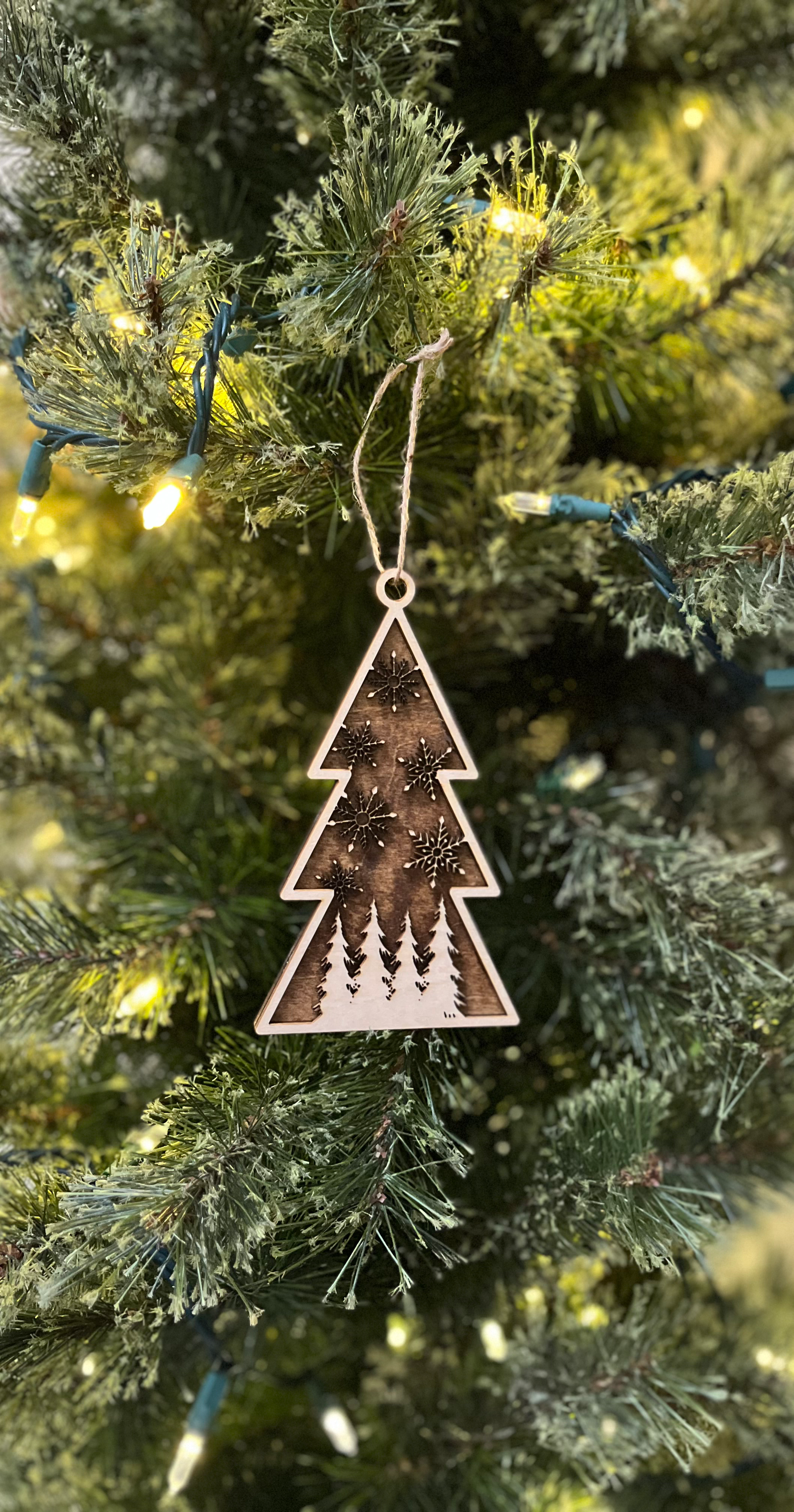 Decorative Christmas tree ornament hanging on a lit Christmas tree.